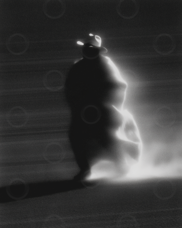 Monochrome backlit drifter in the desert wearing a wide brim hat.