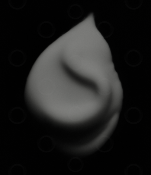 Monochrome white cosmetic cream on a black background.