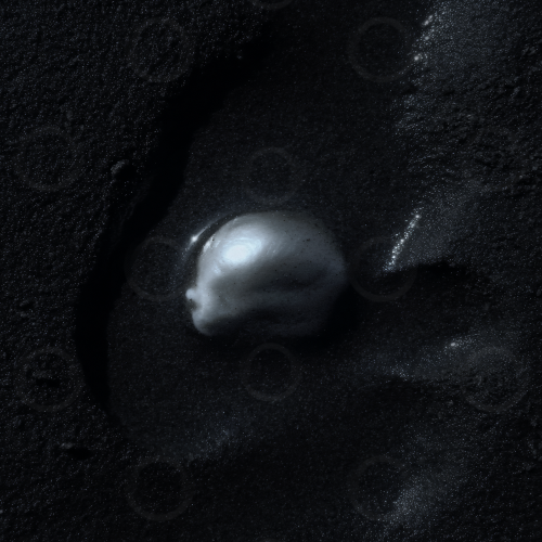 Baroque pearl set in black sand.