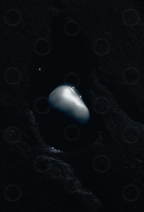 Baroque pearl set in black sand.